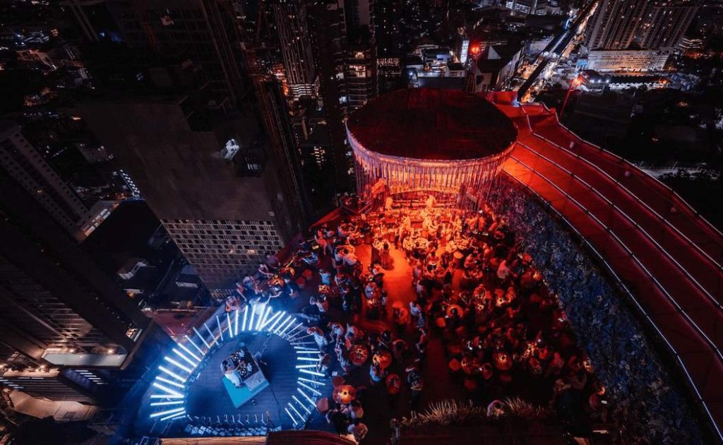 Tichuca busy rooftop with large red LED tree and DJ playing music