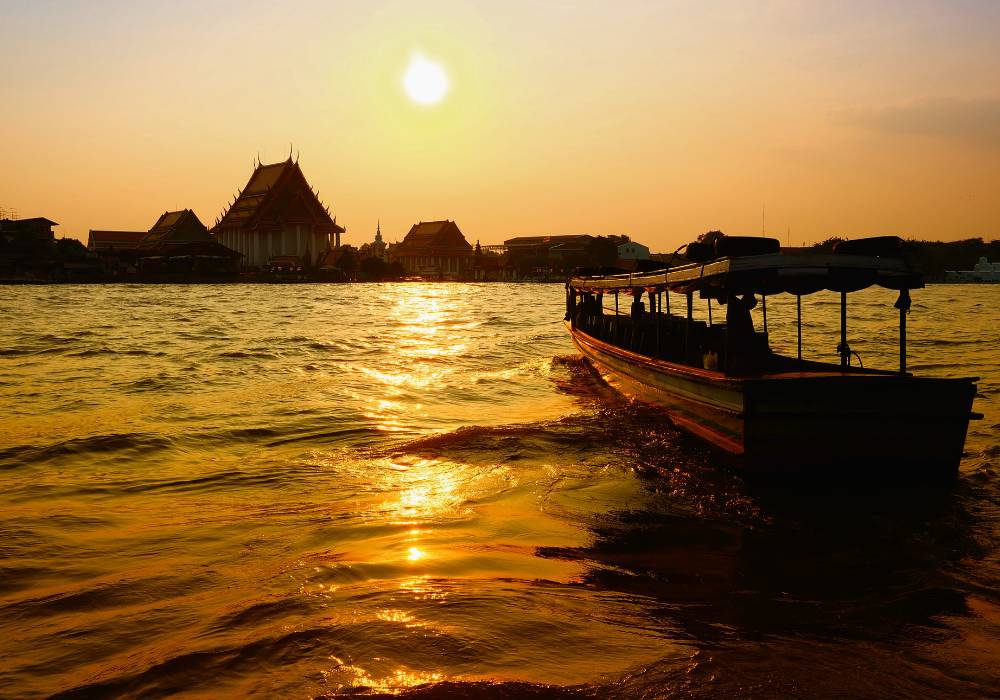 long tail boat in the water during sunset klong tours in bangkok