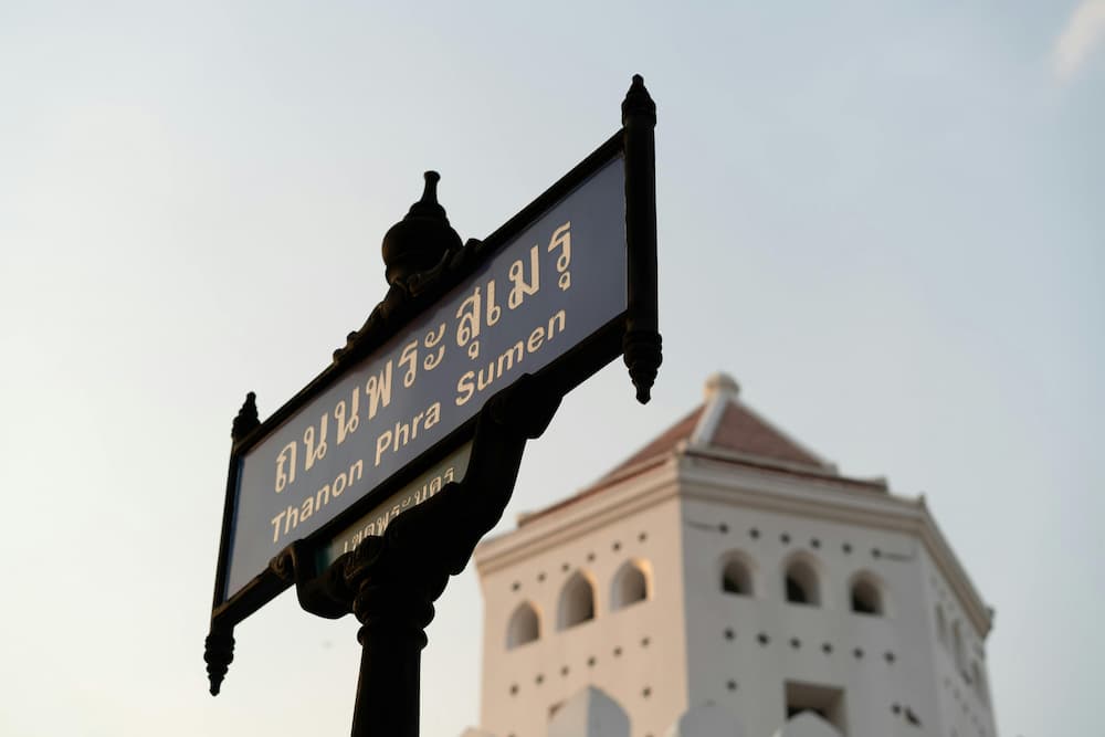 sign saying thanon phra sumen with old fort in the background in bangkok local area